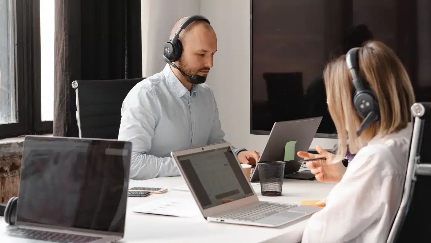 Support team using headsets and laptops in a modern office helpdesk