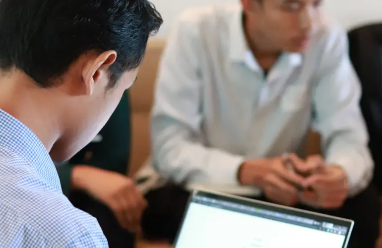 Small business team using laptops together during an office meeting