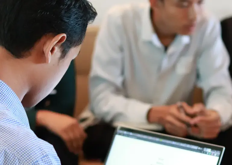 Small business team using laptops together during an office meeting