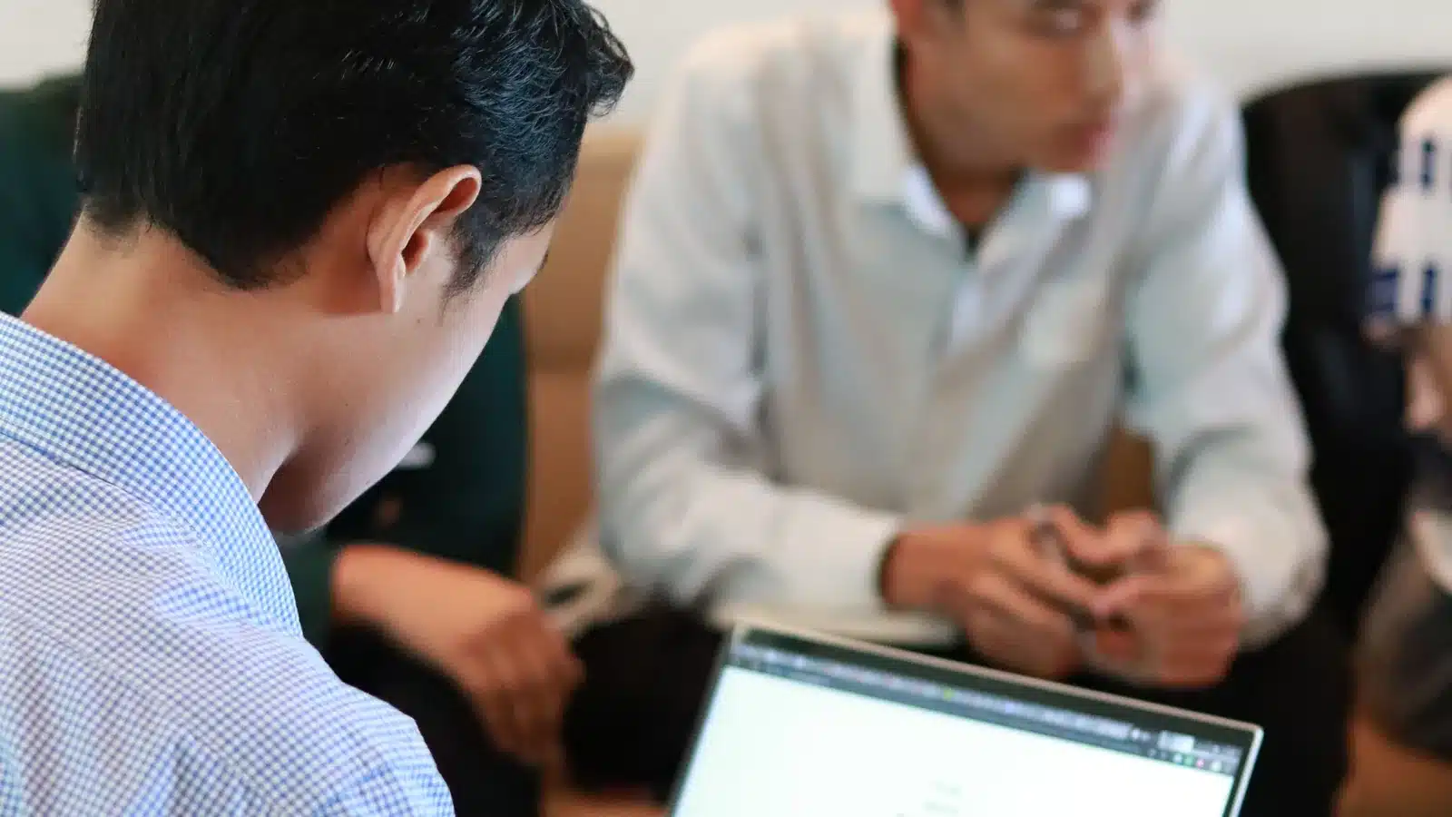 Small business team using laptops together during an office meeting