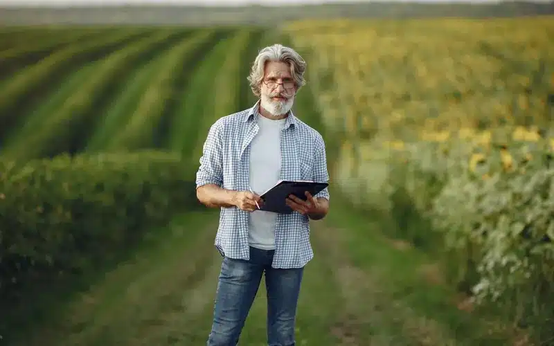 Agribusiness operator using a tablet while working in a crop field