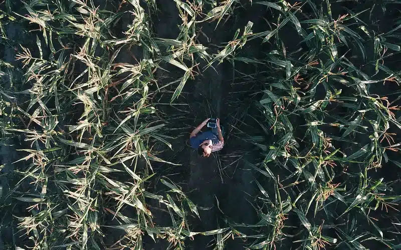 Farmer mapping crop operations with a drone controller in an agricultural field