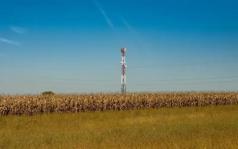 Communication tower beside a rural agricultural field