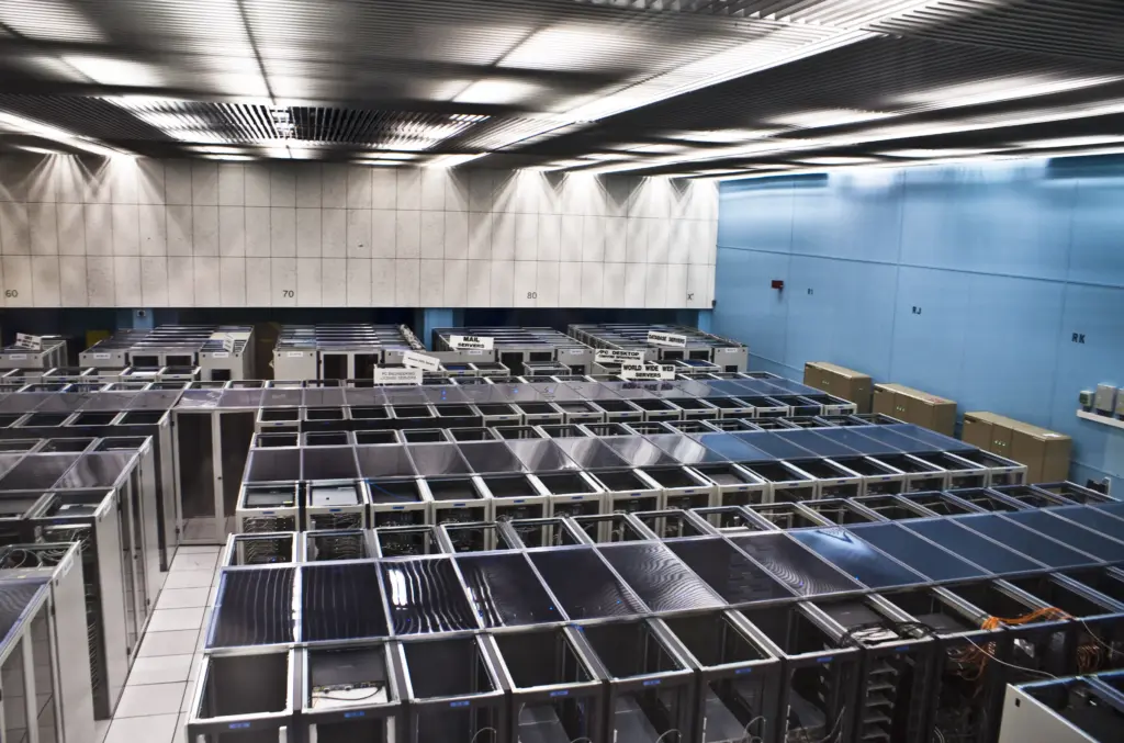 Rows of server racks and labelled computing services in the CERN server room.