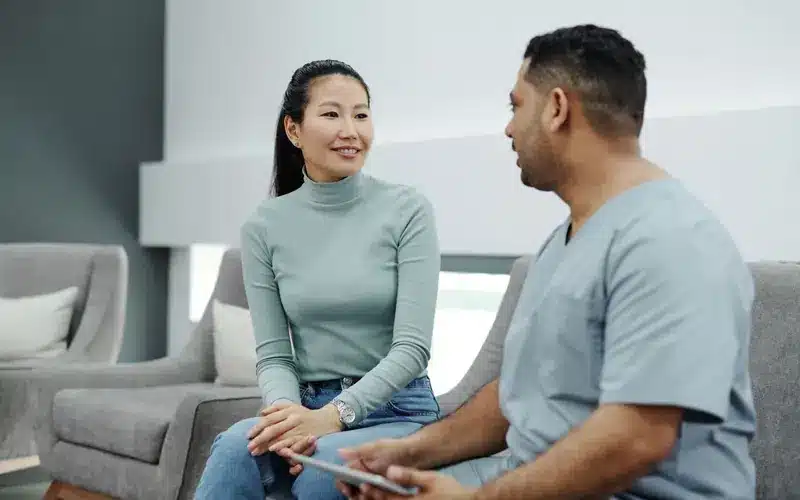 Doctor using a tablet while consulting with a patient in a medical practice