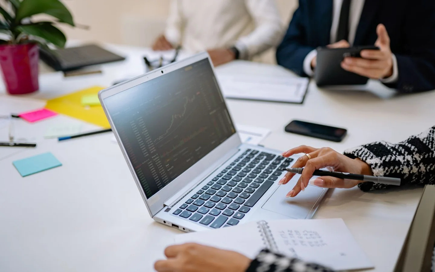 Business colleagues review financial information on a laptop during a meeting